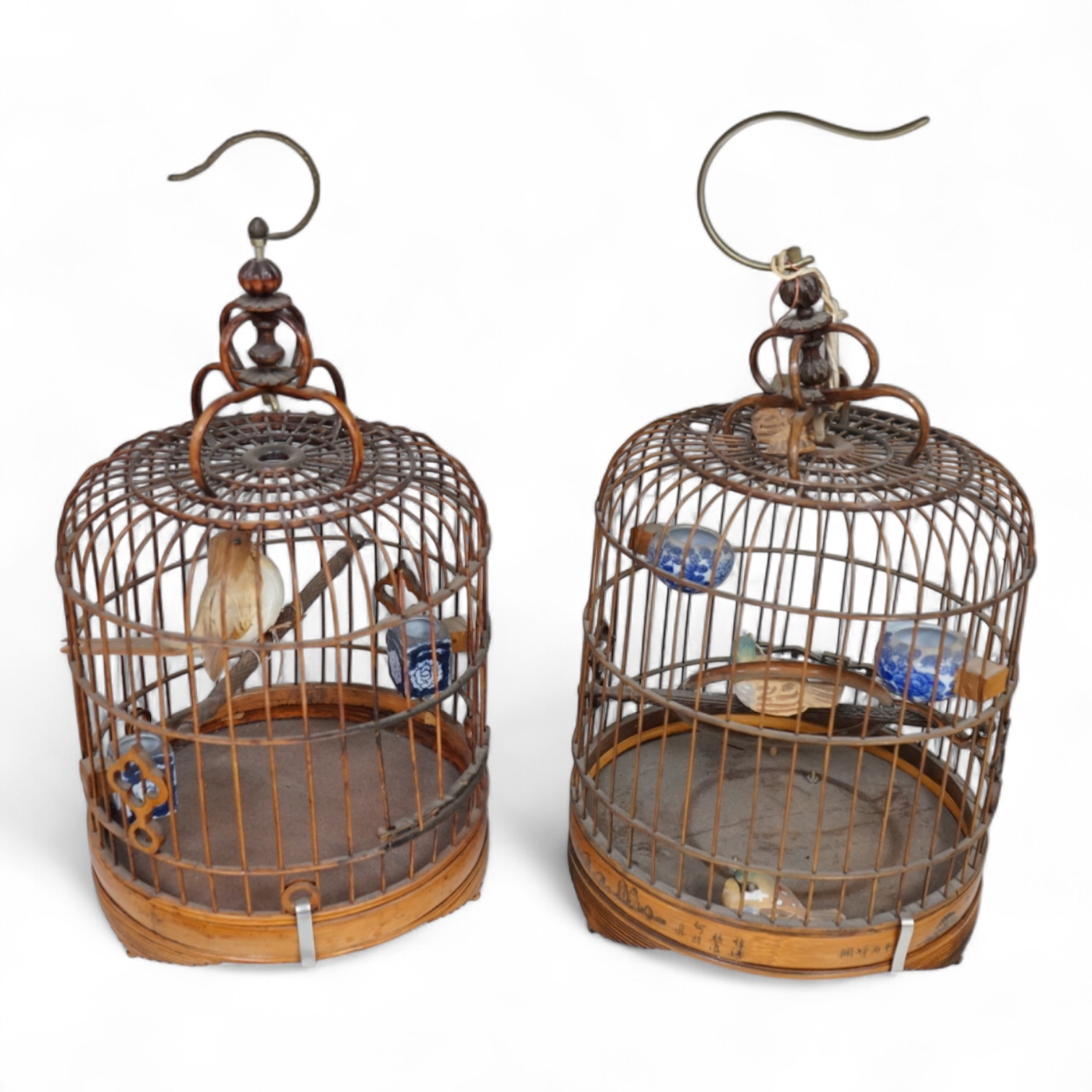 A pair of Chinese bamboo and metal birdcages with blue and white feeders. 34cm high not including hook